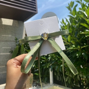 Y2K vintage green lace ribbon bow hair clip with heart pearl center on display card