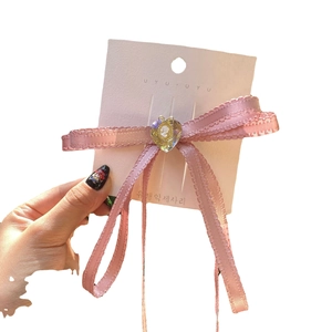 Pink satin ribbon bow hair clip with heart pendant in sweet Y2K aesthetic style