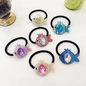 Macro view of six colorful crystal fish hair ties with elastic bands in vibrant colors