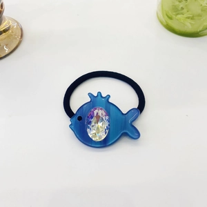 Detail of creative blue fish hair tie with shimmering AB crystal and elastic band