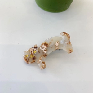 Detail einer Haarklammer aus Acetat in Milchtee-Marmoroptik mit goldener Beschriftung