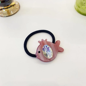 Macro detail of elastic hair tie with pink resin fish and sparkling faceted crystal