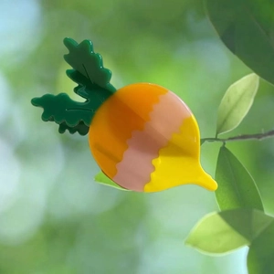 Pince à cheveux carotte en acétate orange et rose avec un design de feuille verte