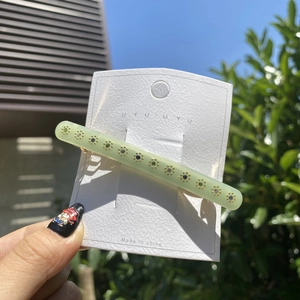 Makroaufnahme der hellgrünen Acetat-Haarklammer mit bunten Strasssteinen in Sonnenform