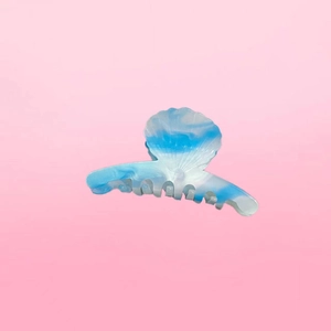 Detailed view of the shell-shaped hair claw clip with blue marble pattern acetate finish