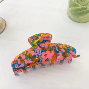 Detailed close-up of a colorful mosaic floral acetate hair claw with high gloss finish