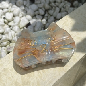 Cute cat claw clip in blue marble resin with gold glitter accents and cat facial details