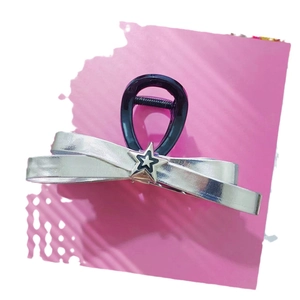 Pince à cheveux noeud argenté métallisé avec étoile sur fond de carte rose