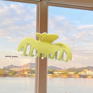 Detail of a large lemon yellow butterfly hair claw clip with a matte finish and firm grip