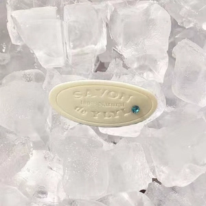 Handmade oval natural soap with blue gemstone on crystal ice background decor