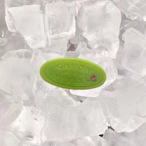 Light green acetate spring hair clip with pink crystal and 100% natural text on ice background