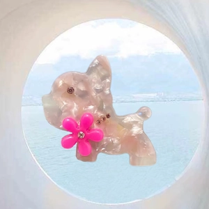 Detailed close-up of a French Bulldog hair clip with acetate finish and pink floral accent