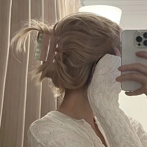 Detailed back view of a pink and mint green marble patterned hair claw clip on a woman's hair