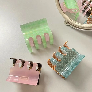 Three-piece acetate hair claw clips set in green marble, pink tortoise, and blue glitter patterns