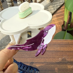Gros plan d'une pince à cheveux baleine violette marbrée en acétate de qualité