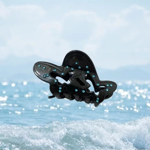 Pince à cheveux papillon noire avec strass bleu clair sur un fond de bord de mer