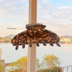 Detail of large acetate hair claw clip with dark tortoiseshell pattern for women
