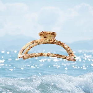 Detail of tortoise shell acetate hair claw clip on a sunny beach background
