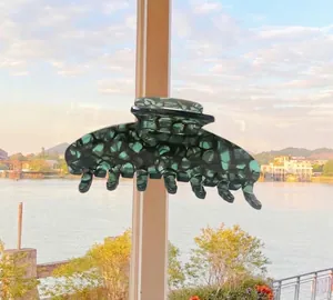 Detailed view of the large dark green tortoiseshell acetate hair claw clip with glossy finish