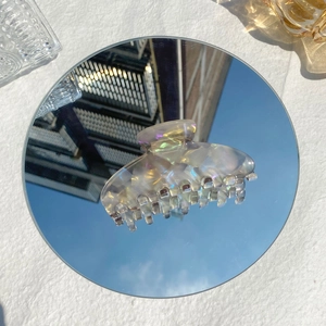 Schillernde Haarklammer aus Acetat, die Himmel und Wolken auf einer Spiegelbasis reflektiert