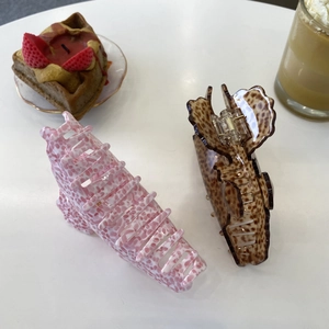 Pink and brown leopard print acetate hair claws in a cozy cafe setting with waffles