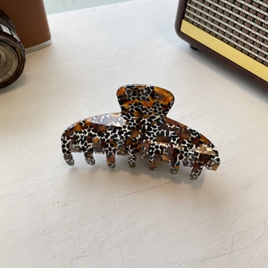 Detail of large acetate hair claw clip featuring stylish leopard shell print pattern