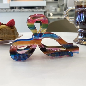 Rainbow gradient clear acrylic hair claw clip on white table with lifestyle background