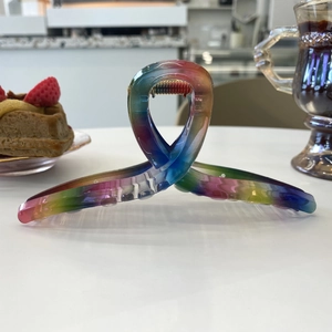 Rainbow gradient acrylic hair claw clip displayed in an elegant lifestyle setting