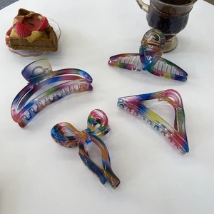 Still life of four colorful marble texture hair claws in a casual afternoon tea setting