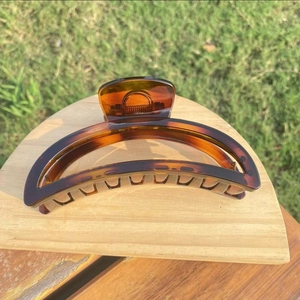 Detailed view of tortoiseshell resin hair claw clip with a hollow semi-circle design
