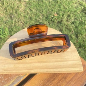 Large tortoiseshell pattern hair claw clip with amber gradient displayed in natural light