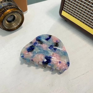 Gros plan sur une pince à cheveux en acétate marbré coloré avec accessoires vintage