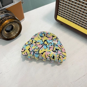 Détail d'une grande pince à cheveux en acétate aux motifs de graffitis abstraits colorés