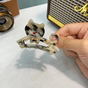 Dettaglio del fermaglio per capelli a gatto in acetato tartarugato con strass colorati