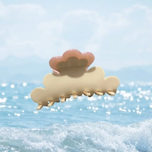 Cellulose acetate cloud flower hair claw clip with rhinestones over ocean water background