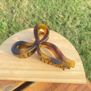 Detailed close-up of tortoise shell pattern bow hair claw clip with anti-slip grip teeth