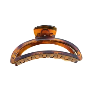 Minimalist amber brown crescent hair claw clip with glossy translucent finish on white background