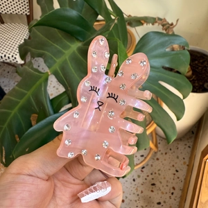 Détail de la pince à cheveux lapin en acétate rose avec strass et motif visage mignon