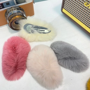 Vue détaillée de barrettes à cheveux en fausse fourrure rose, grise et crème pastel