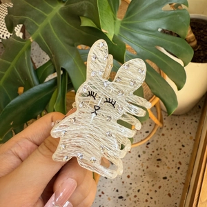 Détail de la pince à cheveux lapin avec strass brillants et texture en acétate