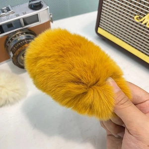 Détail de la texture douce et du matériau en peluche jaune vif de la pince à cheveux