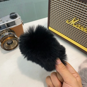 Gros plan sur la barrette à cheveux noire en peluche montrant la texture douce et touffue