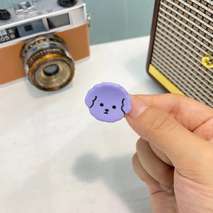 Dettaglio di un piccolo fermaglio per capelli a forma di cane in acetato viola