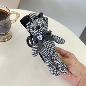 Detail of houndstooth bear hair claw clip with black silk bow and blue heart jewel