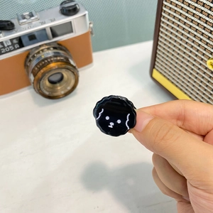 Vista macro di una clip per capelli a forma di cucciolo nero lucido con linee bianche