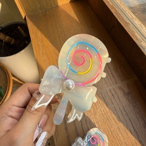 Makro-Detail der Lollipop-Haarklammer mit Perlmutt-Finish und weißer Perlenverzierung