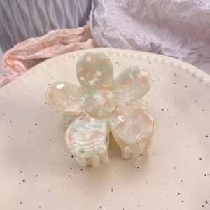 Détail de la pince à cheveux fleur en acétate avec des motifs de marbre pastel