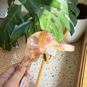 Elegant champagne pink bow hair claw clip with handmade lettering in a natural setting