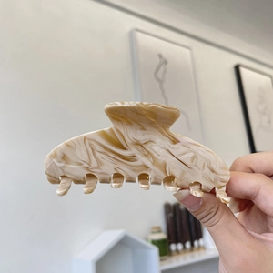 Elegant large acetate hair claw clip with coffee marble texture shown in hand