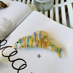 Pince à cheveux dauphin en acétate avec rayures colorées sur fond style de vie